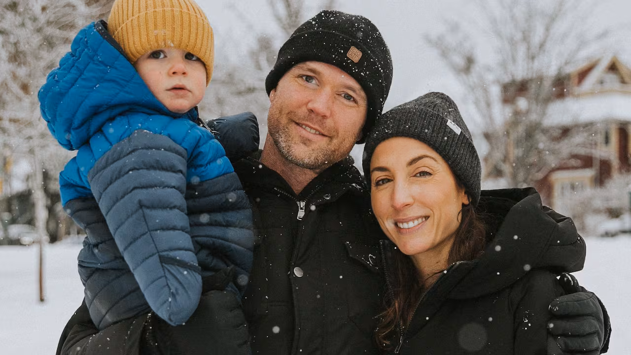 Jenna Dorman and Jay Hoggard stand outside in the snow with their young son.